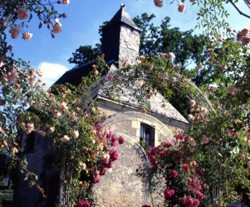 Photographie en couleur de la chapelle Sainte-Anne, entourée de la roseraie du parc de la Balinière, années 1990 (550W/339 ; AMR)