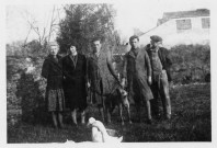 Famille posant avec un chien et des canards : 1 photographie noir et blanc.